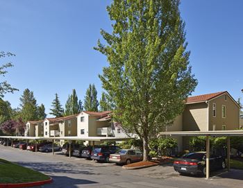 a row of apartments with cars parked in apartment garages at 2000 Lake Washington Apartments, Renton, WA, 98056